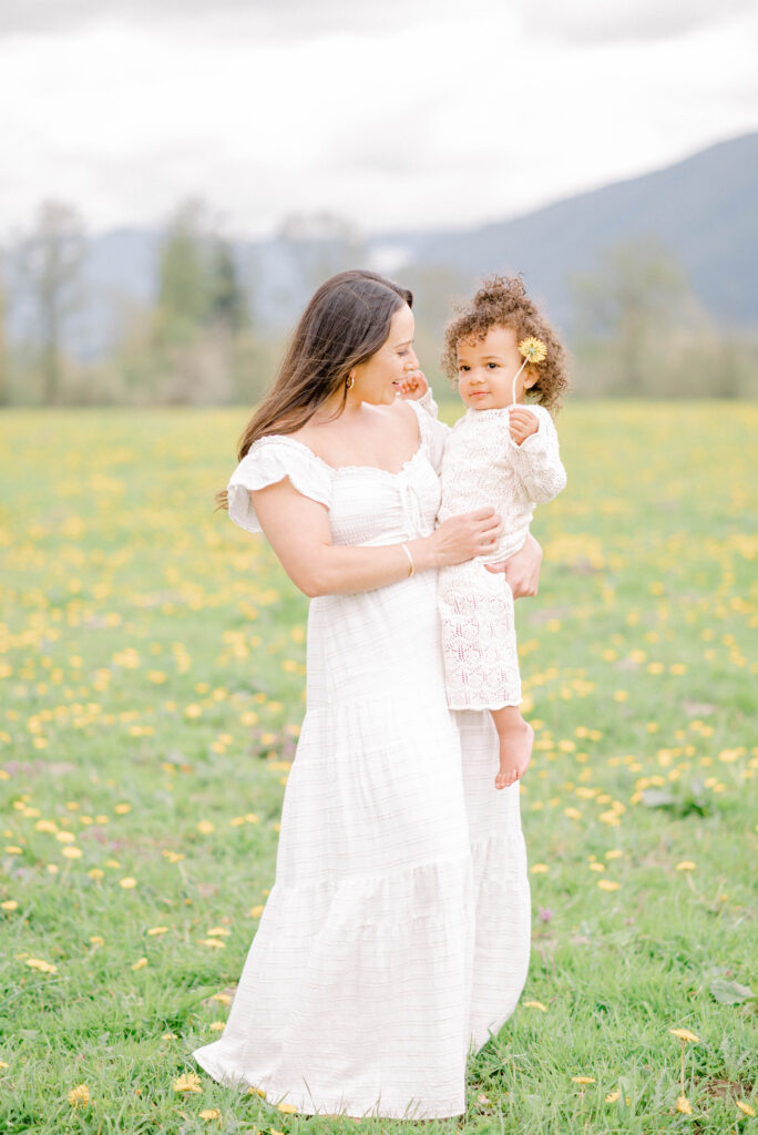 Mother and daughter playing in a field of dandelions in Seattle