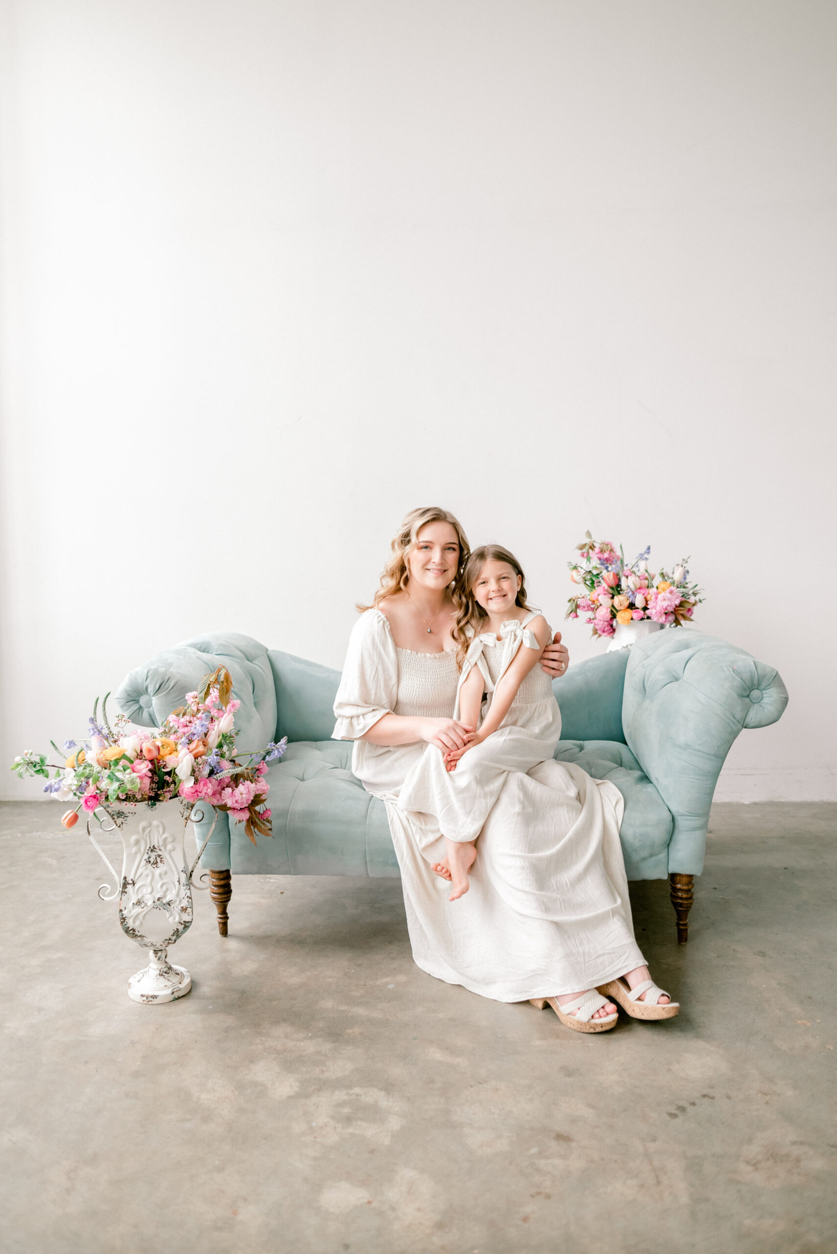 motherhood portrait session with blue couch and spring florals